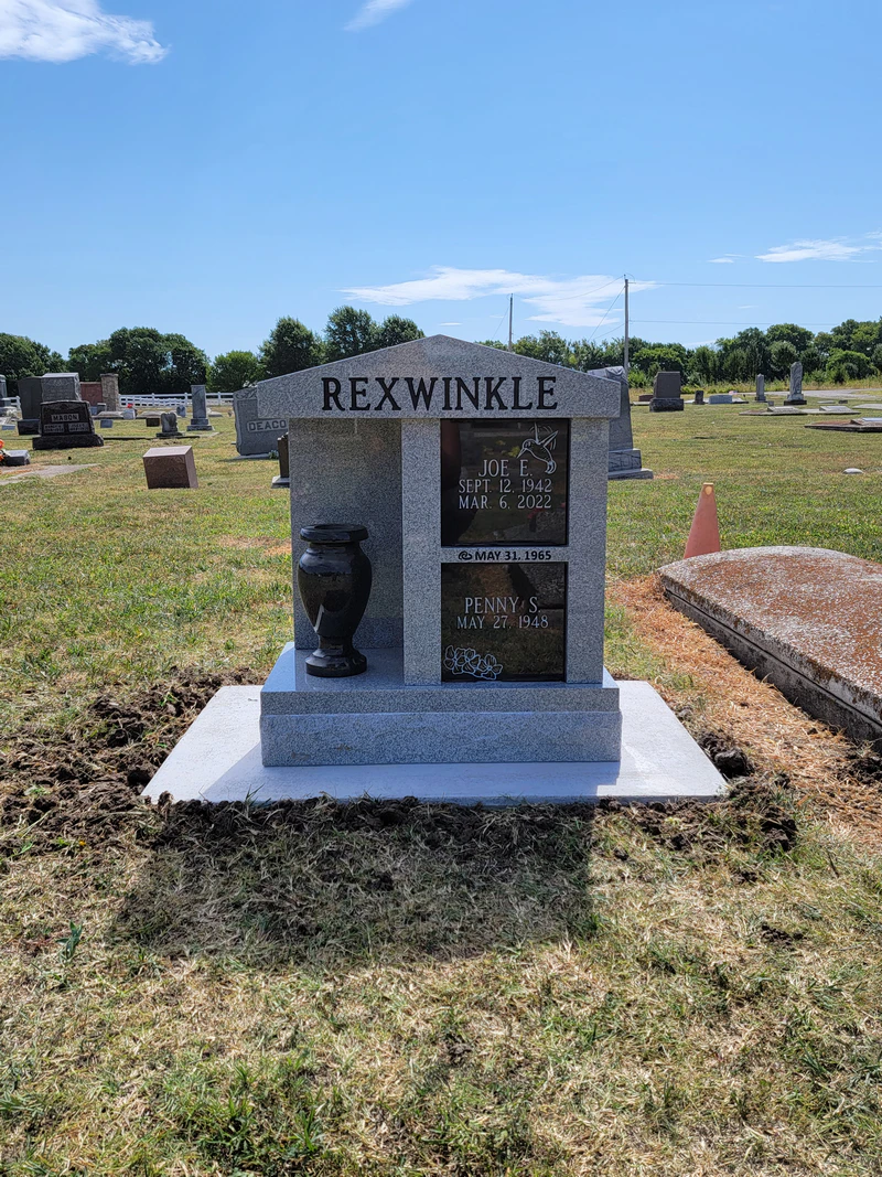 Grey granite cremation memorial with two black granite panels and a granite vase