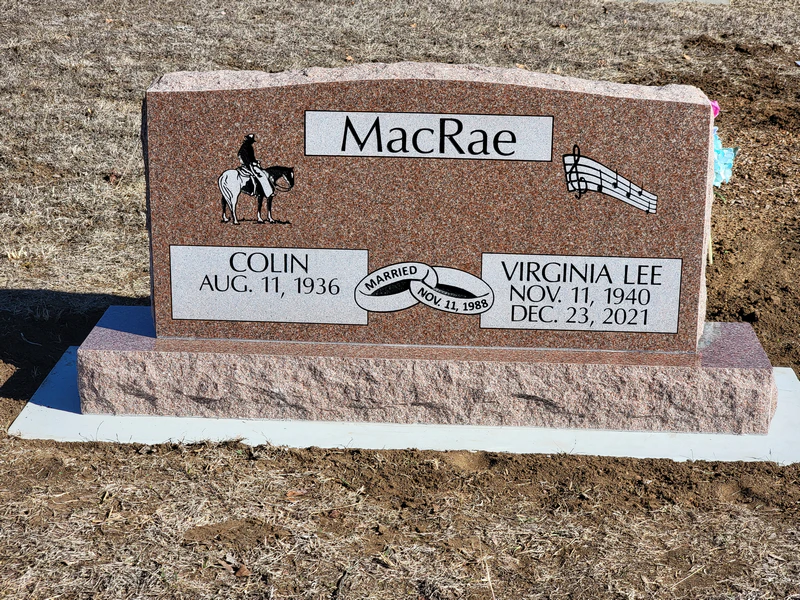 Rose granite slant memorial carved with a horse and rider and a musical staff